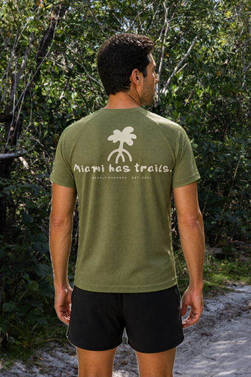Men’s Fern Green MIAMI HAS TRAILS Trail Tee on a model, back view with palm graphic and Miami has trails print.